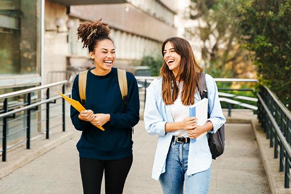 两个女大学生走在校园里笑